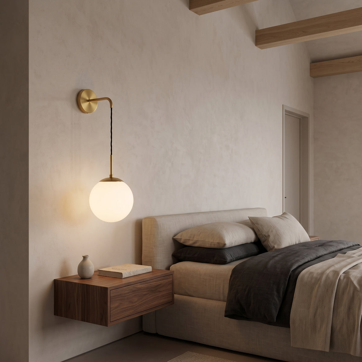 Brass wall sconce with milk white glass globe over a walnut nightstand