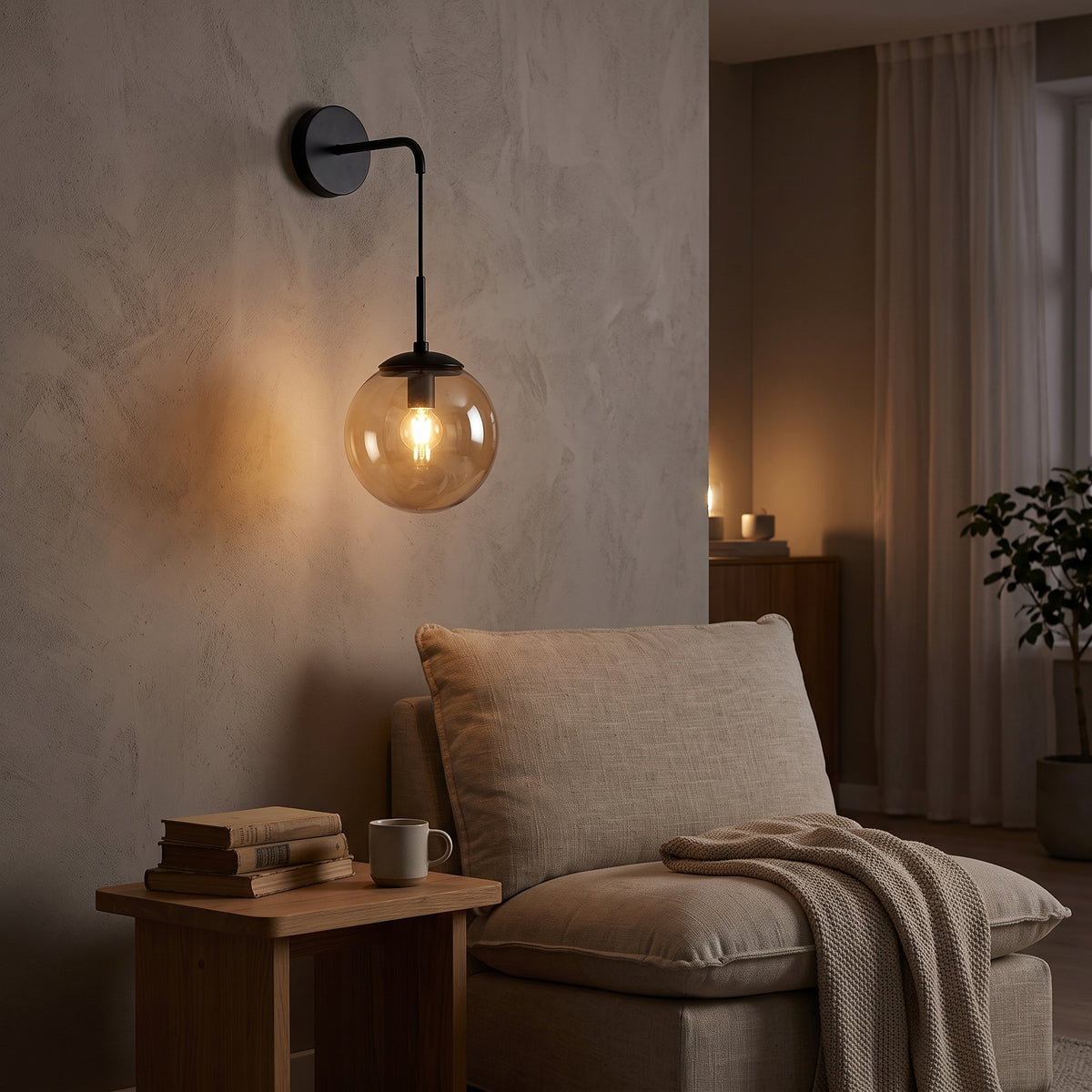 Black hook-arm wall sconce with amber glass globe above a reading chair