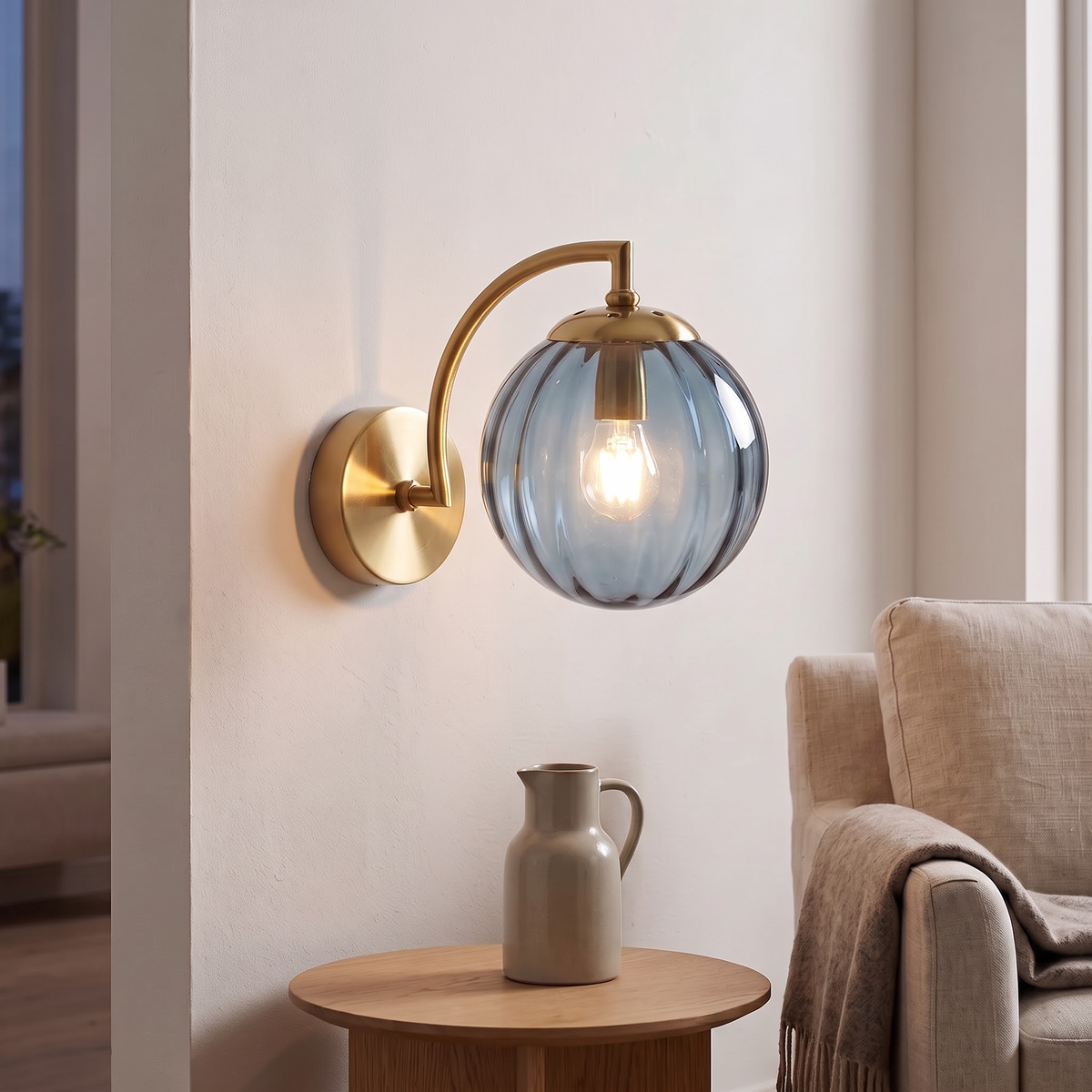 Blue fluted glass globe wall light above an oak side table