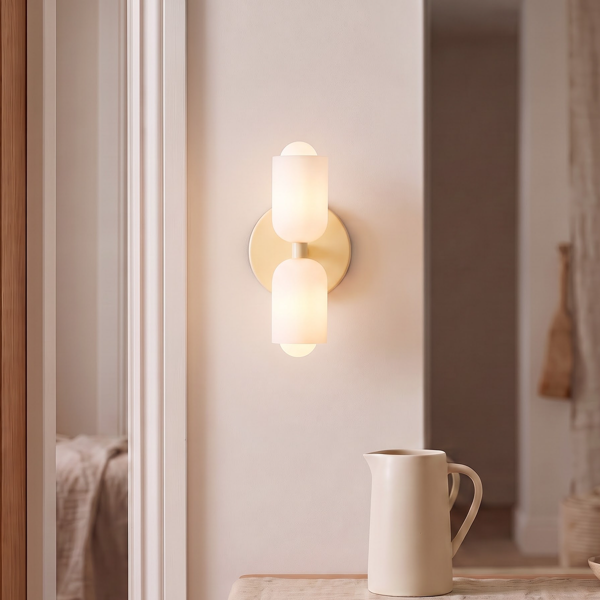 Cream double wall sconce with opal shades beside an oak door frame