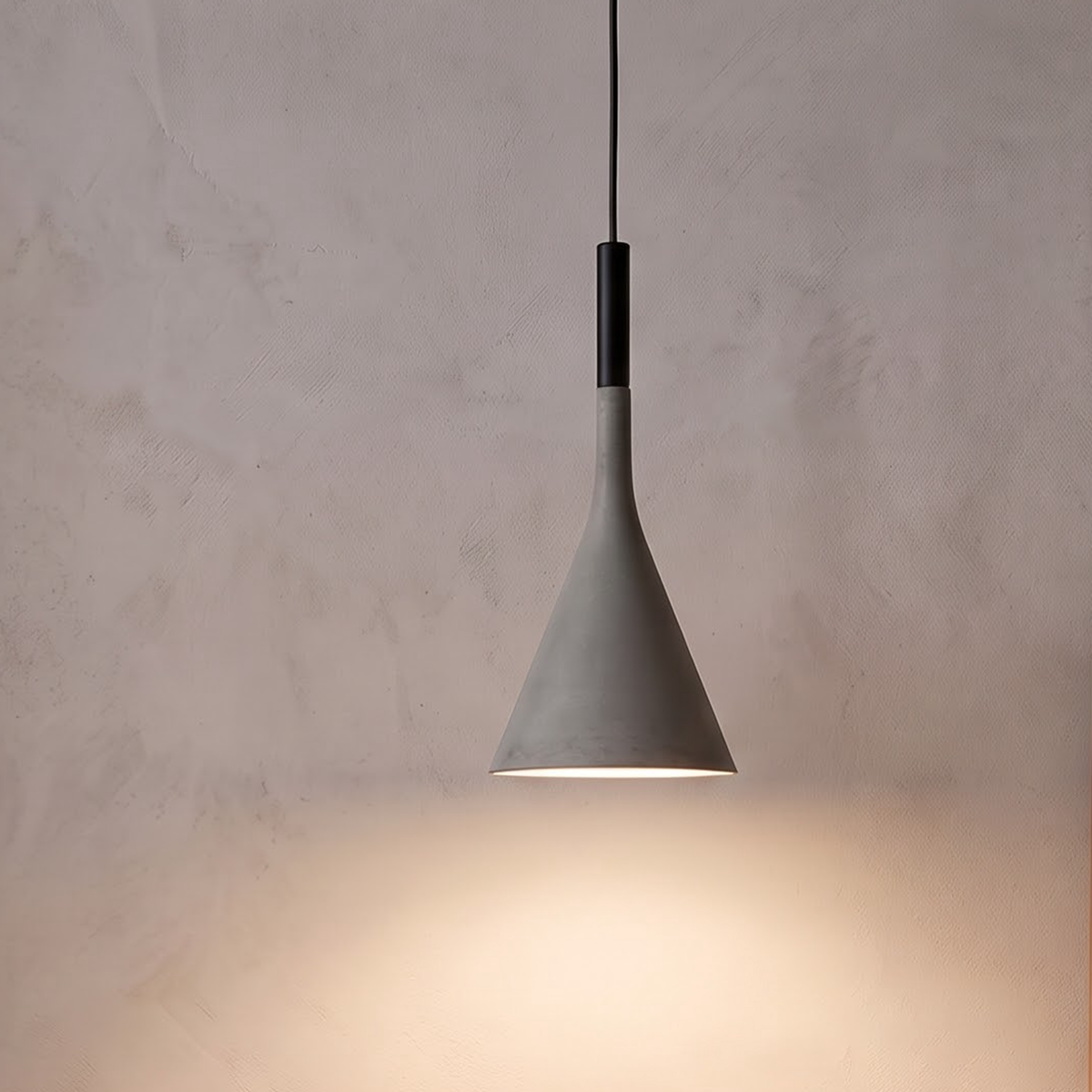 Grey cone pendant light glowing over an oak nightstand in a bedroom