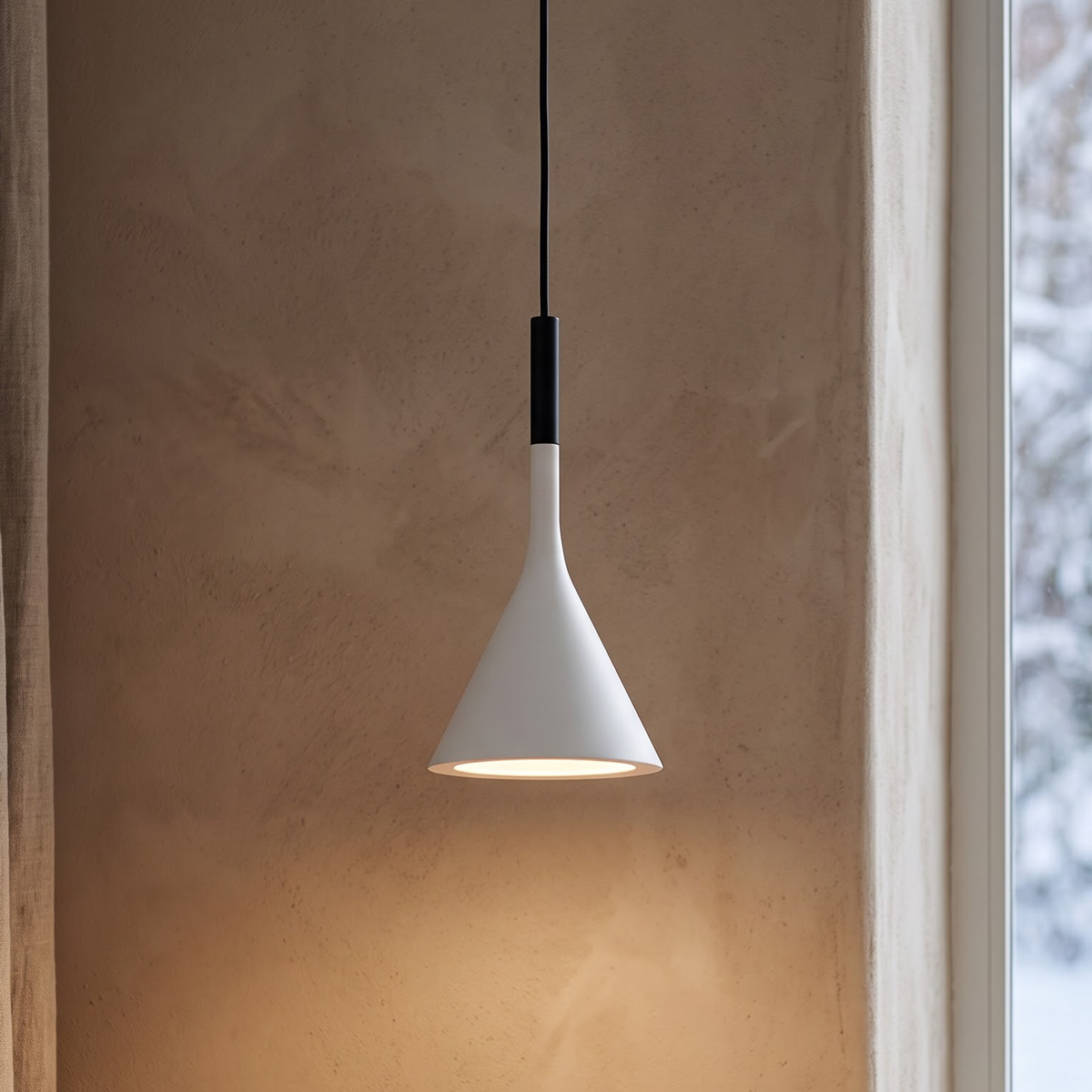 White cone pendant light glowing above a pale oak writing desk