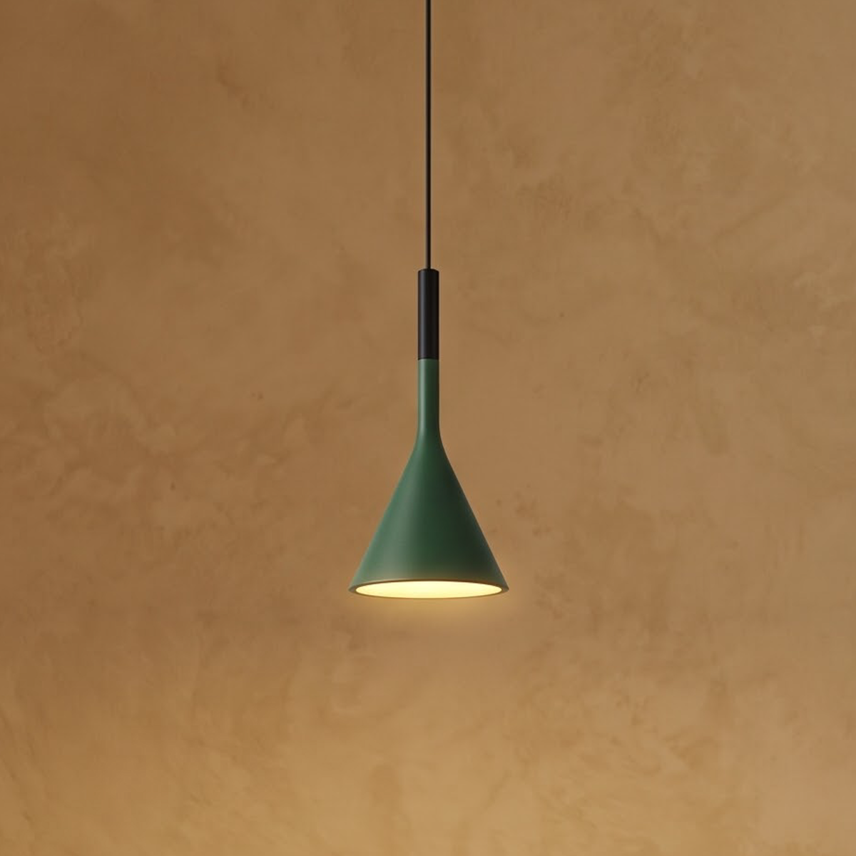 Forest green cone pendant above a travertine side table at evening
