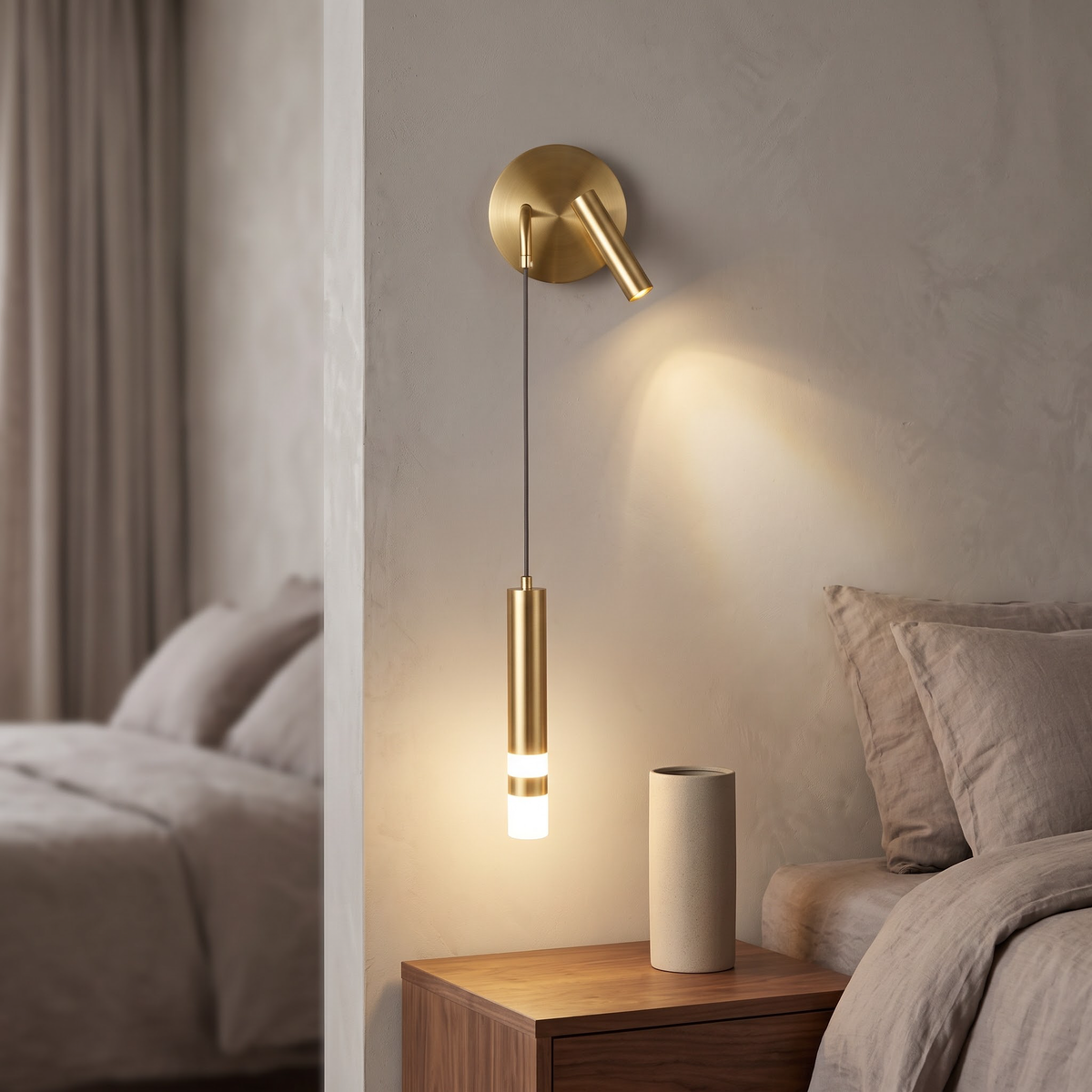 Gold wall light with reading spot and hanging tube above a nightstand