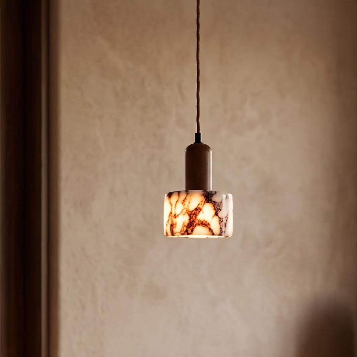 Plum-veined marble pendant with wood cap glowing over a walnut counter
