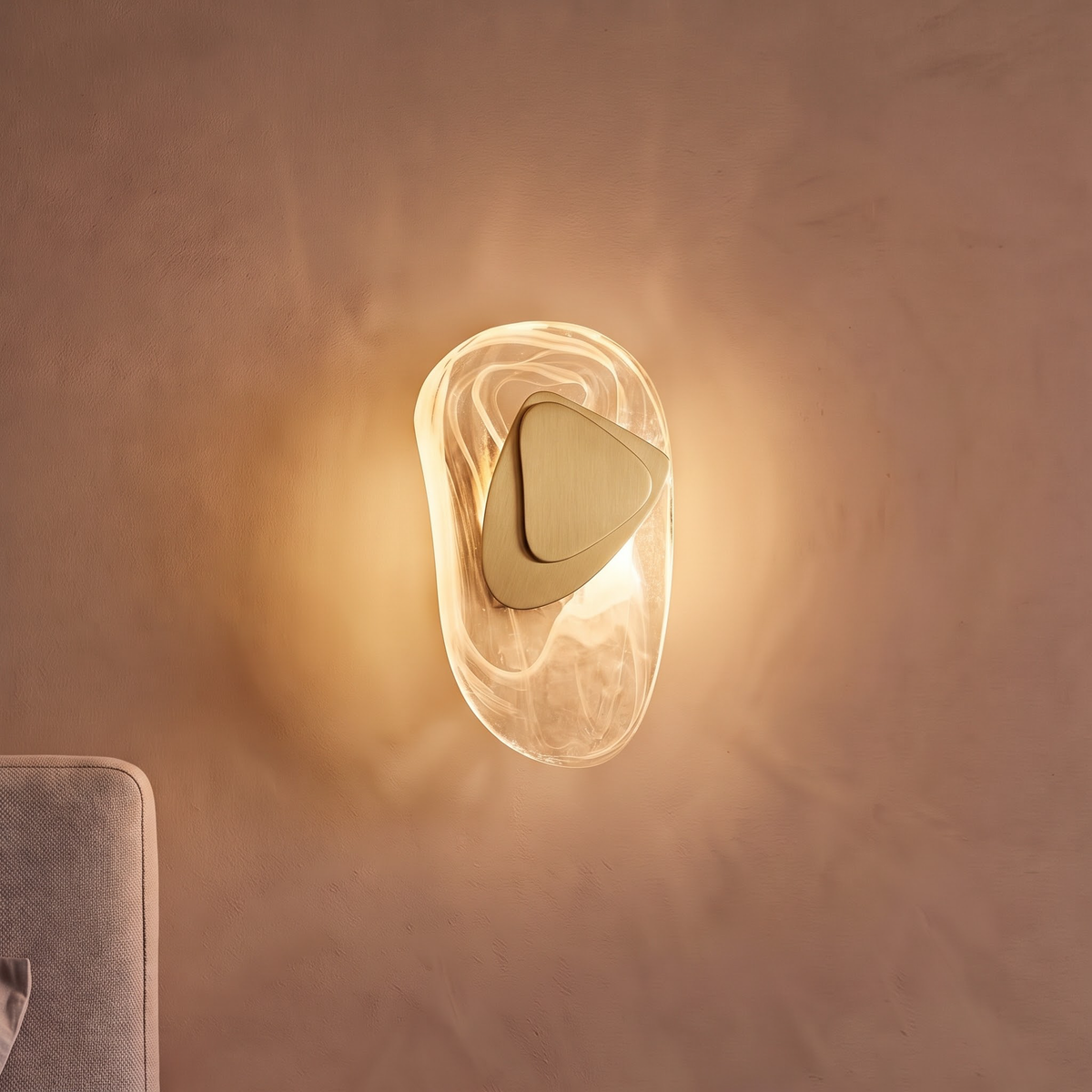 Swirled glass pebble wall light with brushed gold plate glowing