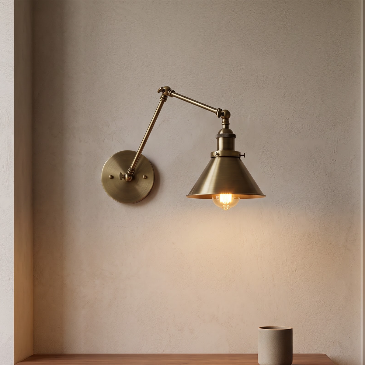 Antique brass swing-arm wall lamp with cone shade above a desk