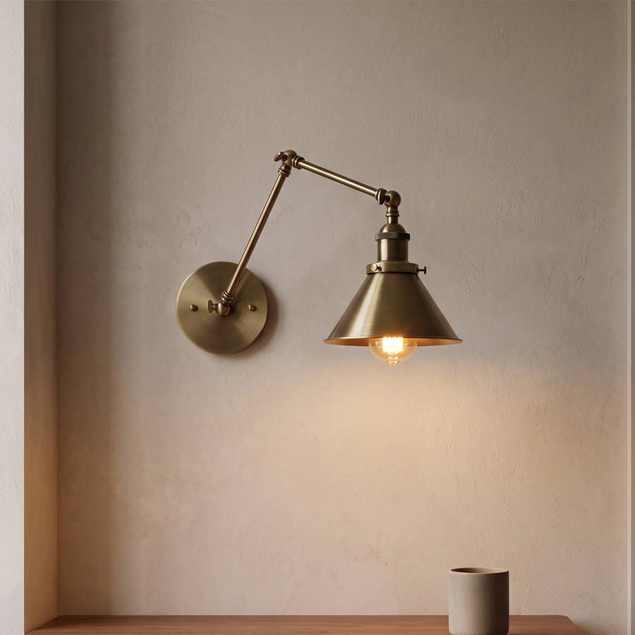 Antique brass swing-arm wall lamp with cone shade above a desk